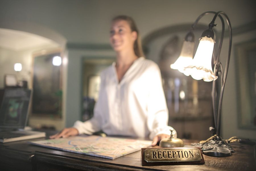hotel front desk with verified guest identity data flowing to the PMS